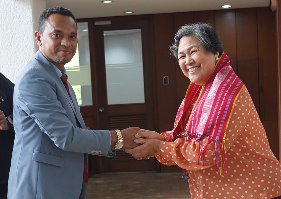 Secretary de Araujo (left) gifts Dr. Sombilla (right) a tais, Timor-Leste's handwoven traditional textile