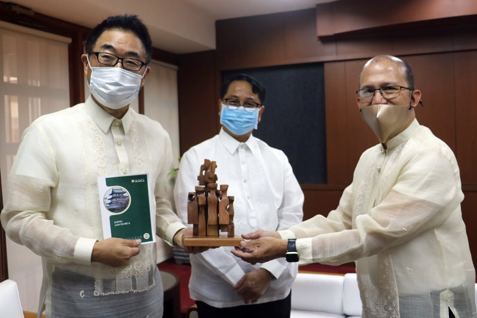 Japanese Ambassador Koshikawa Kasuhiko (left) holds a compendium on the collaborations between Japan and SEARCA since the 1970s and a mini replica of SEARCA’s Growth Monument presented to him Dr. Glenn B. Gregorio (right), SEARCA Director, while University of the Philippines (UP) President Danilo L. Concepcion looks on. The SEARCA Growth Monument consists of 11 stylized human figures linked internally on a square base, symbolizing synergy amid the diversity of the Southeast Asian Ministers of Education Organization (SEAMEO) member countries toward a more prosperous Southeast Asia.