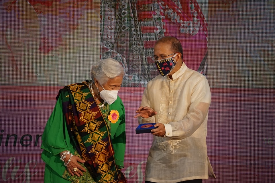 Dr. Gregorio presents a paper weight bearing a montage of the Secretary and H. rosa-sinensis ‘Leonor Magtolis Briones’ to Sec. Briones (left).