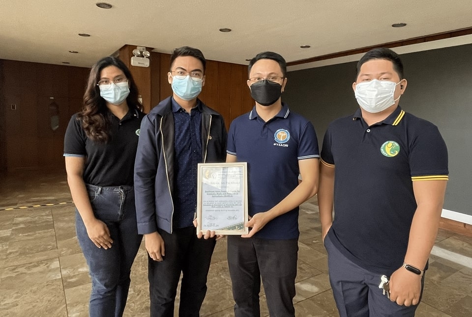 Mr. Sonny P. Pasiona (second from right), SEARCA Senior Communications Associate and Youth Lead, and Mr. Nathan P. Felix, (second from left), SEARCA Senior Public Relations Associate, hold a certificate of recognition from Gawad Laguna, Inc. (GLI) Vice President Mr. Lionell Aniciete and Deputy Vice President For. Raiza Mae Togado.