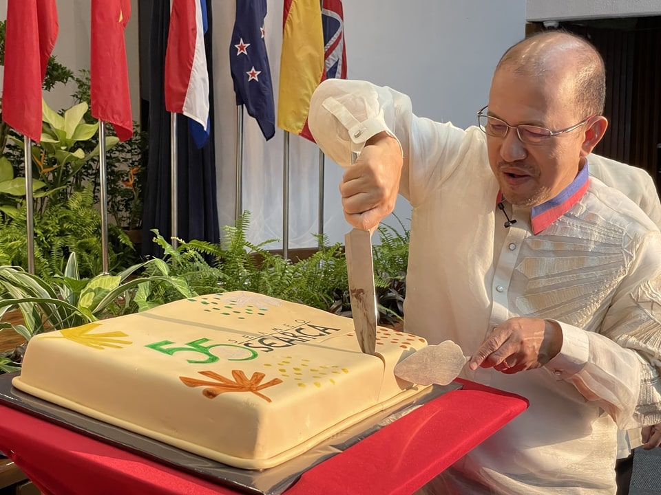 Dr. Gregorio cuts a cake bearing the 55th Anniversary logo.