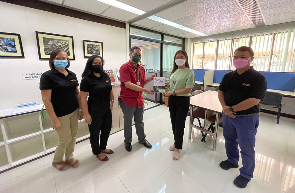 Dr. Clores holds another publication that SEARCA wishes to donate to DEBESMSCAT as presented to her by Mr. Juliano. Also in the photo are Dr. Labios (rightmost), Ms. Mina G. Talata (leftmost), Library and Archives Associate, and Ms. Arlene A. Nadres (second from left), Support Staff, both from AKRU.