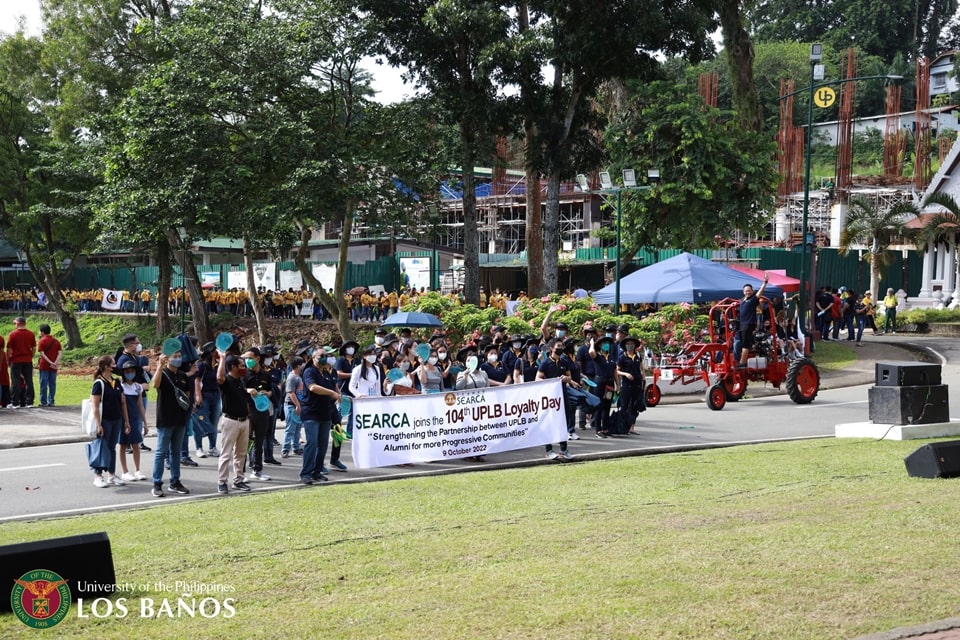SEARCA staff and scholars parade in the 104th UPLB Loyalty Day celebration as Assoc. Prof. Joselito G. Florendo, SEARCA Deputy Director for Administration, cheerfully waves while riding the Center’s prototype Ronnie Baugh / Oggun Tractor, which it is developing to support farm mechanization via sustainable and regenerative agriculture. (photo grabbed from the UPLB Facebook Page)