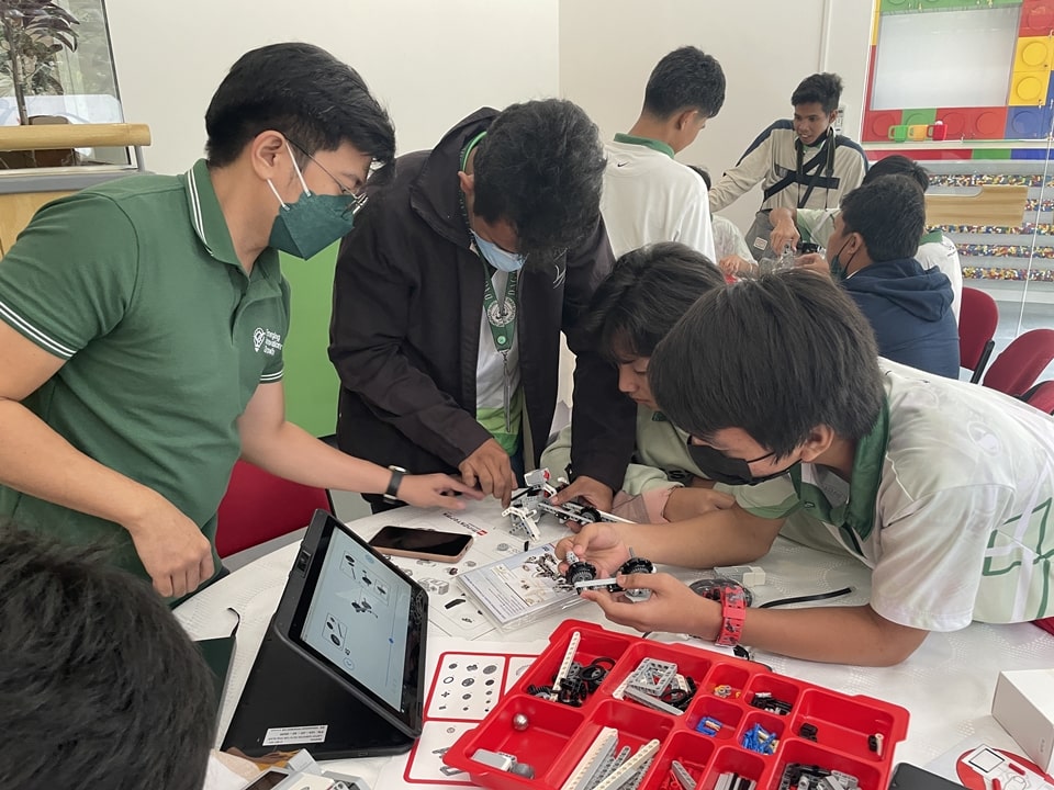 Mr. Jerrel Edric Mallari (leftmost), Project Assistant, EIGD, teaches a group of students how to build their own robotic Lego set (EV3Lab).