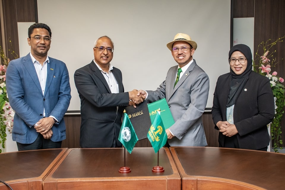 Dr. Glenn Gregorio (second from right), SEARCA director, and Prof. Shobhakar Dhakal, AIT vice president for academics, shake hands after exchanging copies of the signed Memorandum of Understanding for institutional cooperation. They are flanked by Dr. Nur Azura Adam, SEARCA deputy director for programs, on the right and Prof. Sangam Shrestha of the AIT Water Engineering and Management Program.