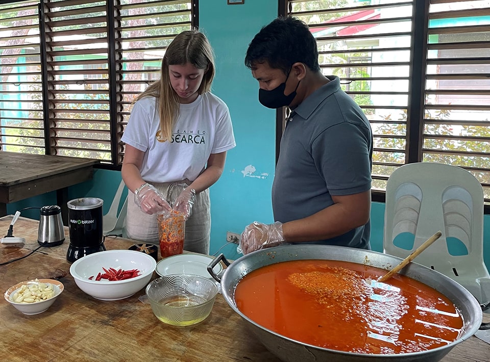 Mr. Feria guides Edith Coronel, intern from ISARA Lyon, France, in mixing the ingredients of DFFS' chili garlic oil