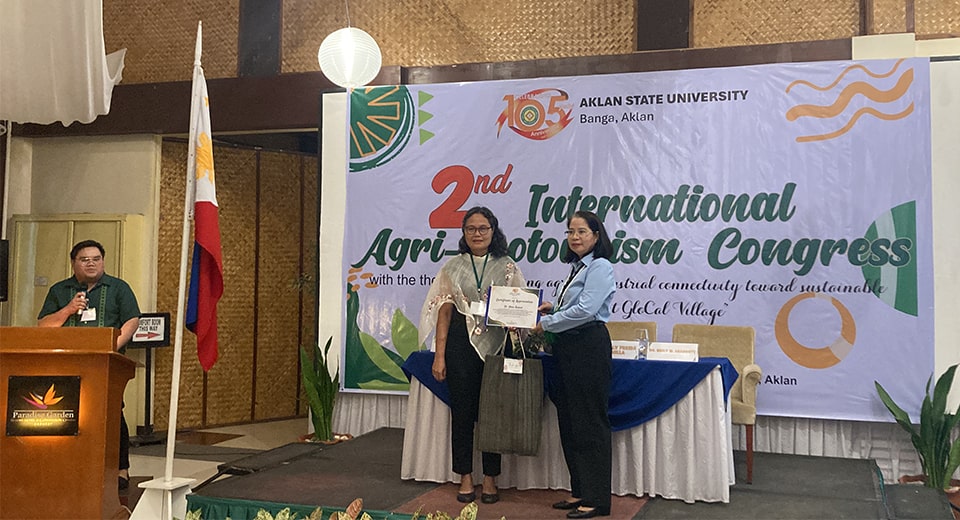 Dr. Ramos receives a certificate and token of appreciation from, Dr. Melba Raga-as, director, Research and Development Services, Aklan State University (ASU). Also in photo (leftmost) is Dr. Tonylen De Jose of ASU who served as moderator for the event.