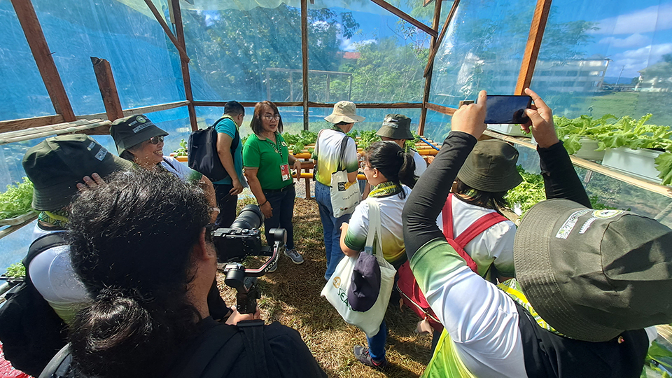 A representative from DepEd-Kabankalan briefs the participants on the hydroponics facility in Tabugon's school garden.