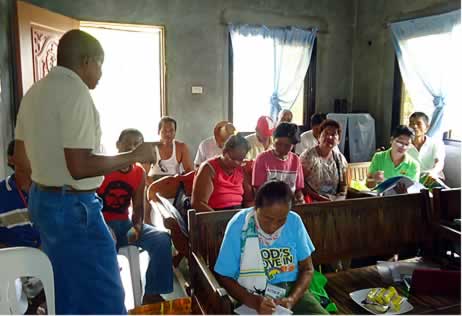 Prof. Williams (left) presents the outputs delivered by the SEARCA project team before the members of Farmer Vegetable Credit Cooperative during their special General Assembly on 11 August 2014 in Cabiao, Nueva Ecija. 