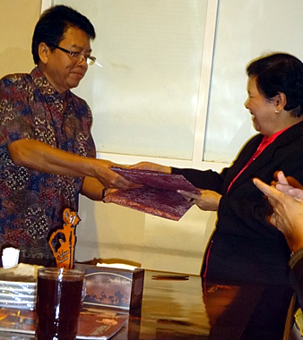 Prof. Dr. Wani Hadi Utomo, UNITRI Rector, and Dr. Elsa P. Manarpaac, WPU President, exchange their signed copies of their MOU