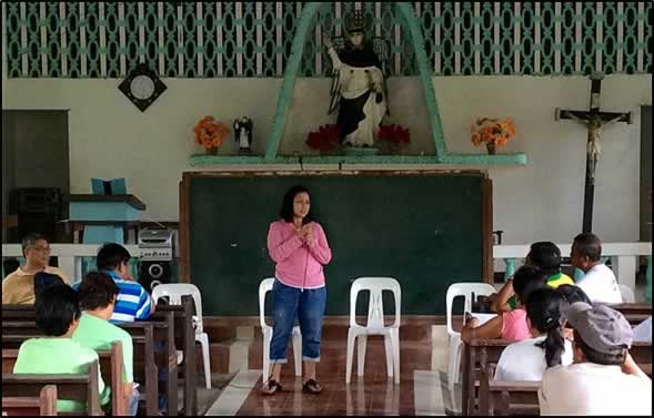 Dr. Bessie M. Burgos, SEARCA’s head of Research, addresses  pressing issues and concerns raised by cooperative members and local  farmers in a local chapel used as assembly area in Malinao, Aklan.