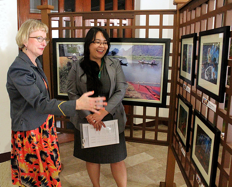 Ms. Avril D. Madrid, Program Specialist, Knowledge Resources (right), explains to the Ambassador some of winning photos of SEARCA’s Photo Contest.