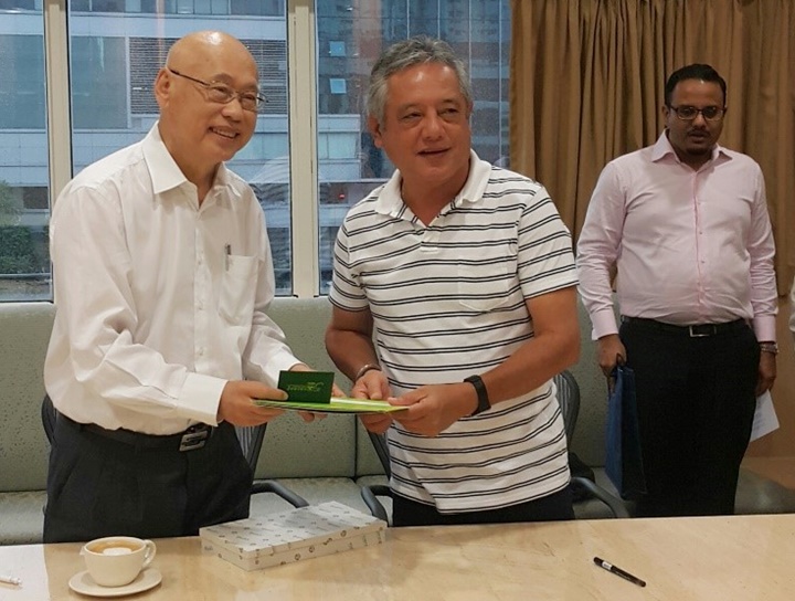 Dr. Saguiguit presents SEARCA briefing materials and a replica of the Growth Monument, SEARCA’s institutional symbol, to Mr. Lim. Looking on is Mr. Vignesh Naidu, Research and Project Manager.