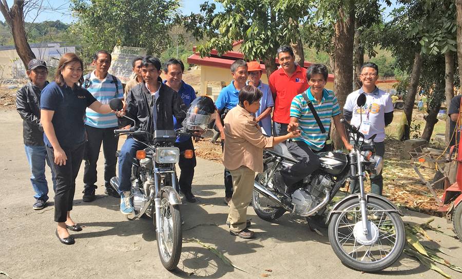 Ms. Nancy Landicho (leftmost), SEARCA Program Specialist, and Dir. Gloria Dela Cruz (front row, third from left), PCC Center Director at DMMMSU award the motorcycles to Mr. Rolly C. Mateo (on motorcycle, left), Chairman, BSNMPC; and Mr. Vicente Eblogan (on motorcycle, right), Treasurer of RDPA. | Back row (L-R): Mr. Fermin Q. Jamias, BOD; Mr. Leonardo Jamias, Treasurer; Mr. Edgar Niedo, Manager- all of BSNMPC; Mr. Reynaldo D. Paneda, SRA/AI Coordinator, PCC at DMMMSU; Mr. Victoriano P. Petina, Jr., President; Mr. Ricardo C. Eblogan, Sr. Vice President, all of RDPA; and Mr. Albert D. Nieva, staff of PCC at DMMMSU.