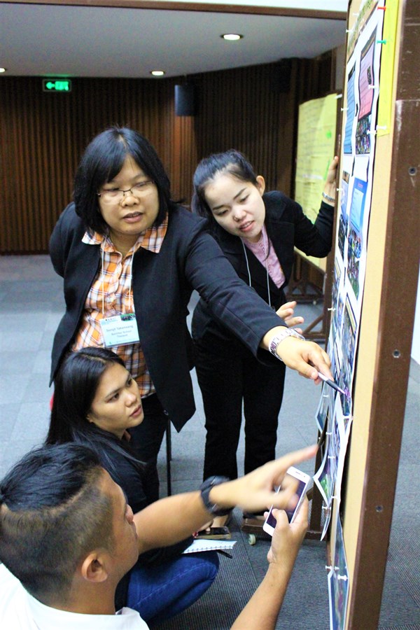 Participants from Thailand schools showcasing their initiatives related to school and home gardens using poster charts in the information marketplace.